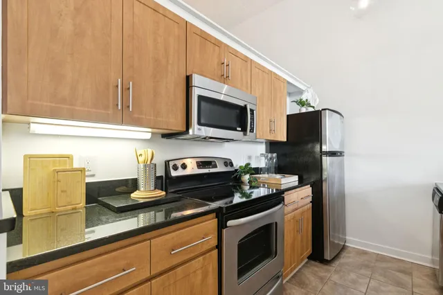 a kitchen with stainless steel appliances granite countertop a stove a microwave and a refrigerator