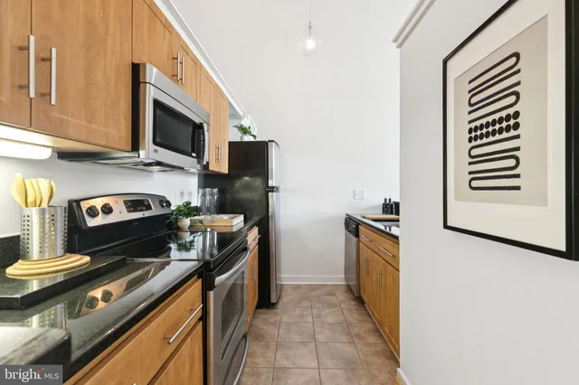 a kitchen with stainless steel appliances a stove a sink and a microwave