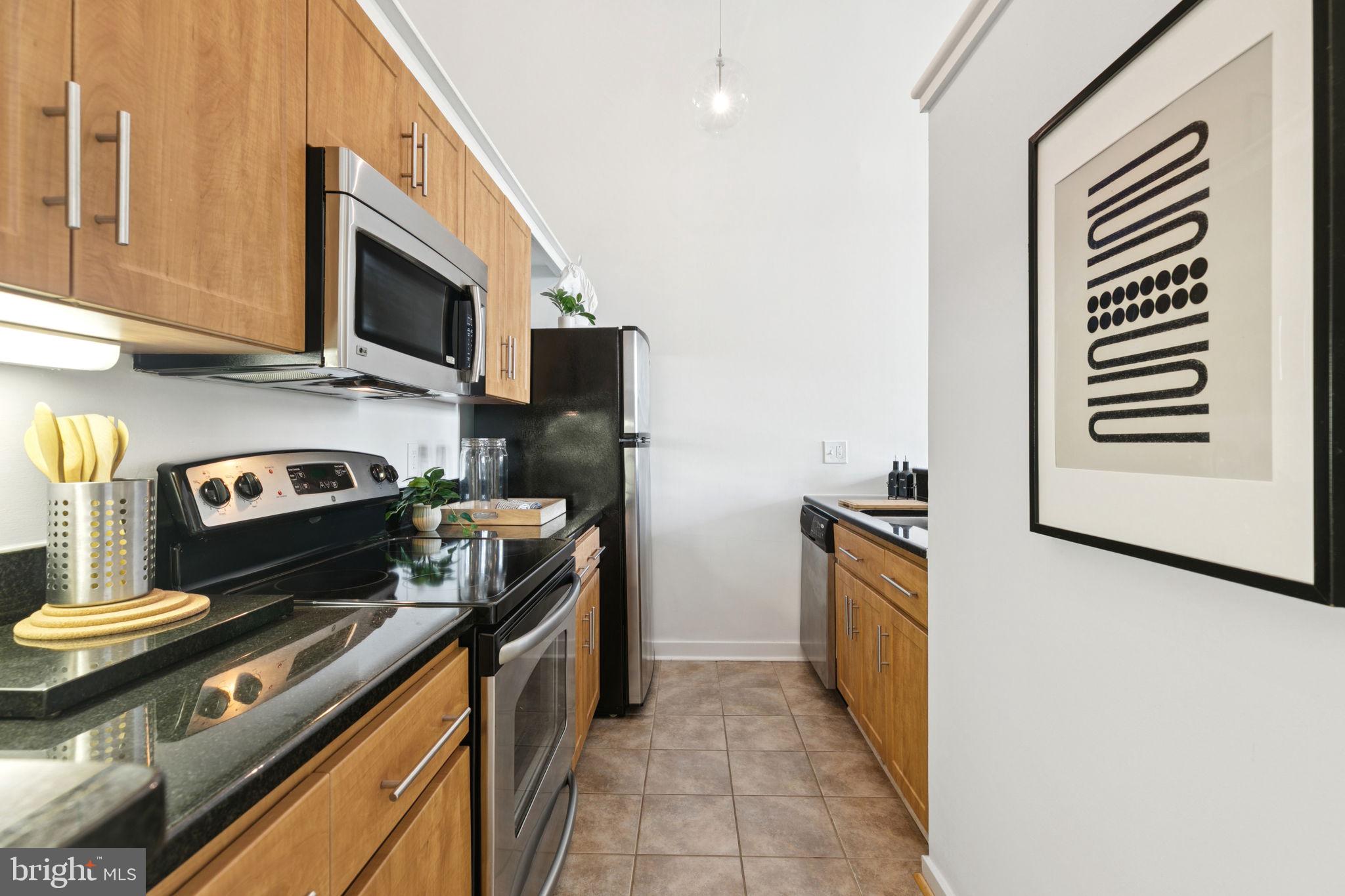 2429 Locust Street, Unit 318 Philadelphia, PA 19103 - Photo 10 of 35 a kitchen with stainless steel appliances a stove a sink and a microwave