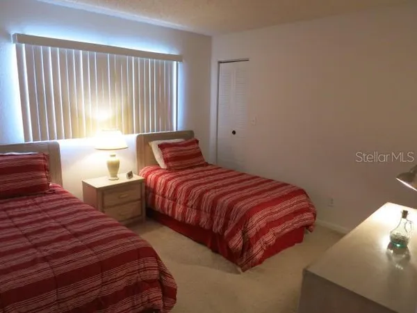 a bedroom with two beds and a large window