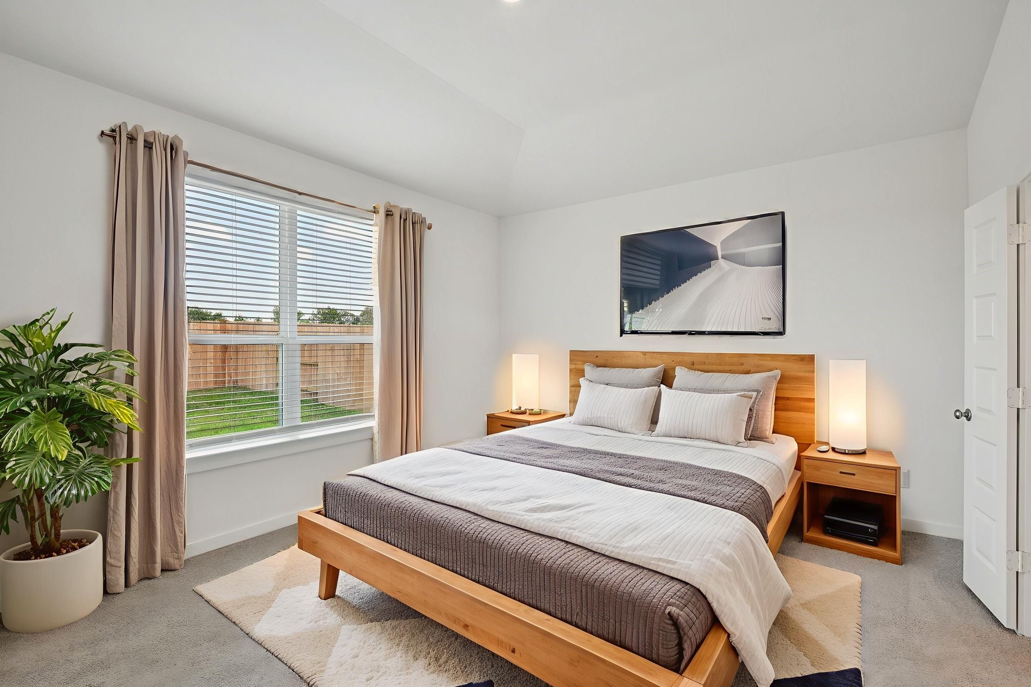 a bedroom with a large bed and a potted plant