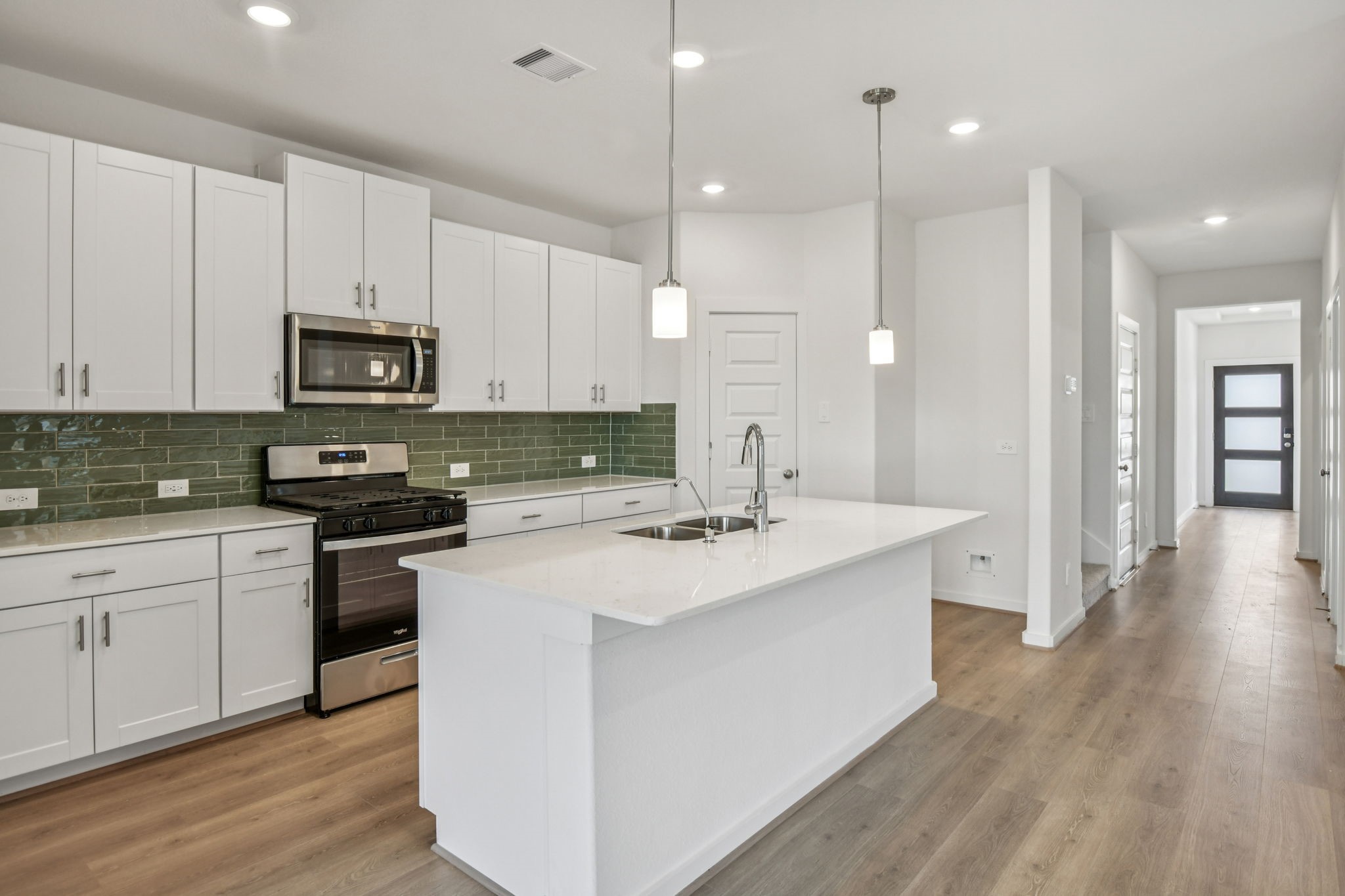 6631 Castella Drive Rosharon, TX 77583 - Photo 16 of 47 a kitchen with stainless steel appliances granite countertop a sink a stove a refrigerator and white cabinets with wooden floor