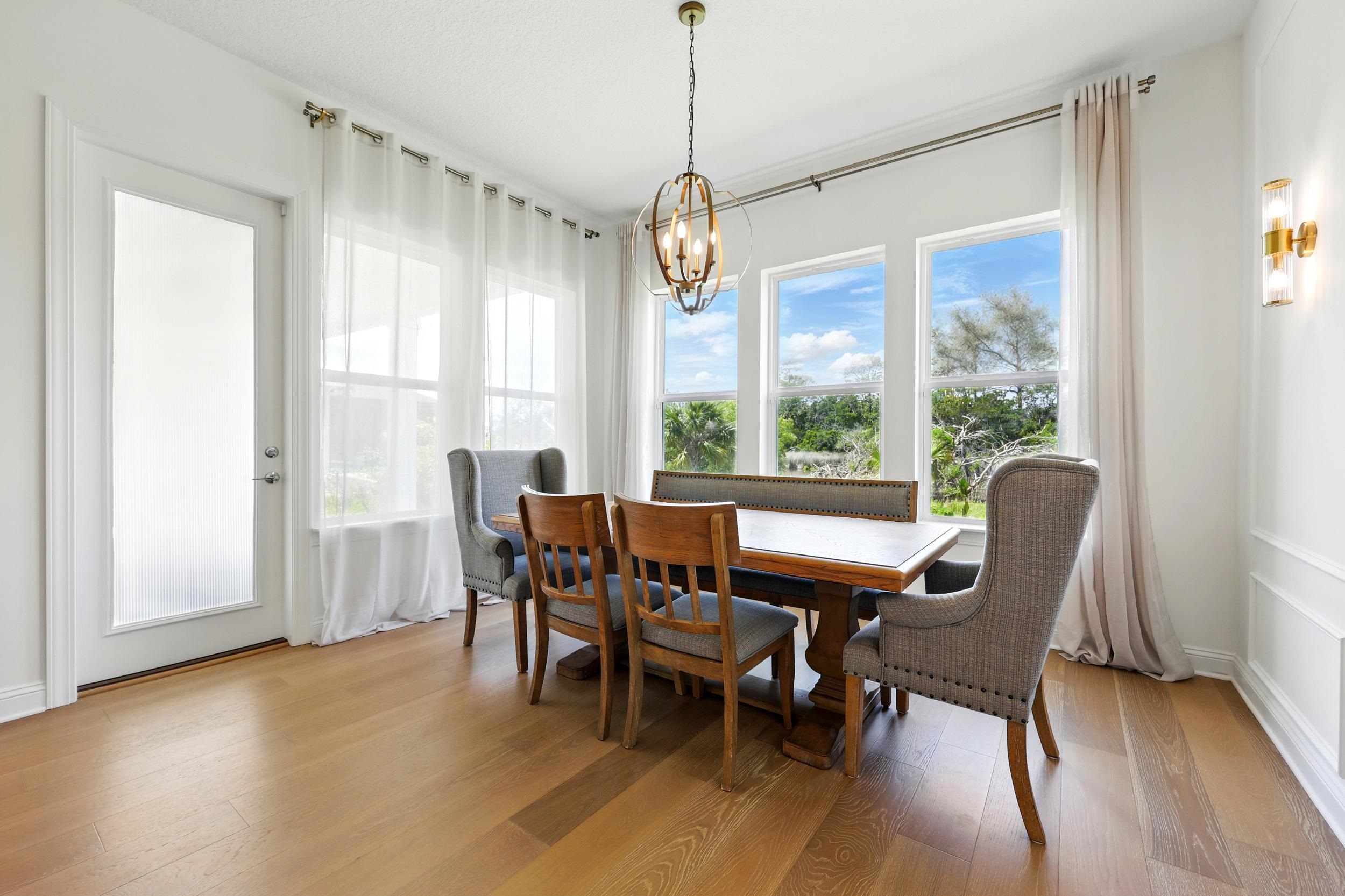 164 Tesoro Terrace St. Augustine, FL 32095 - Photo 18 of 55 a dining room with wooden floor a chandelier a glass table and chairs