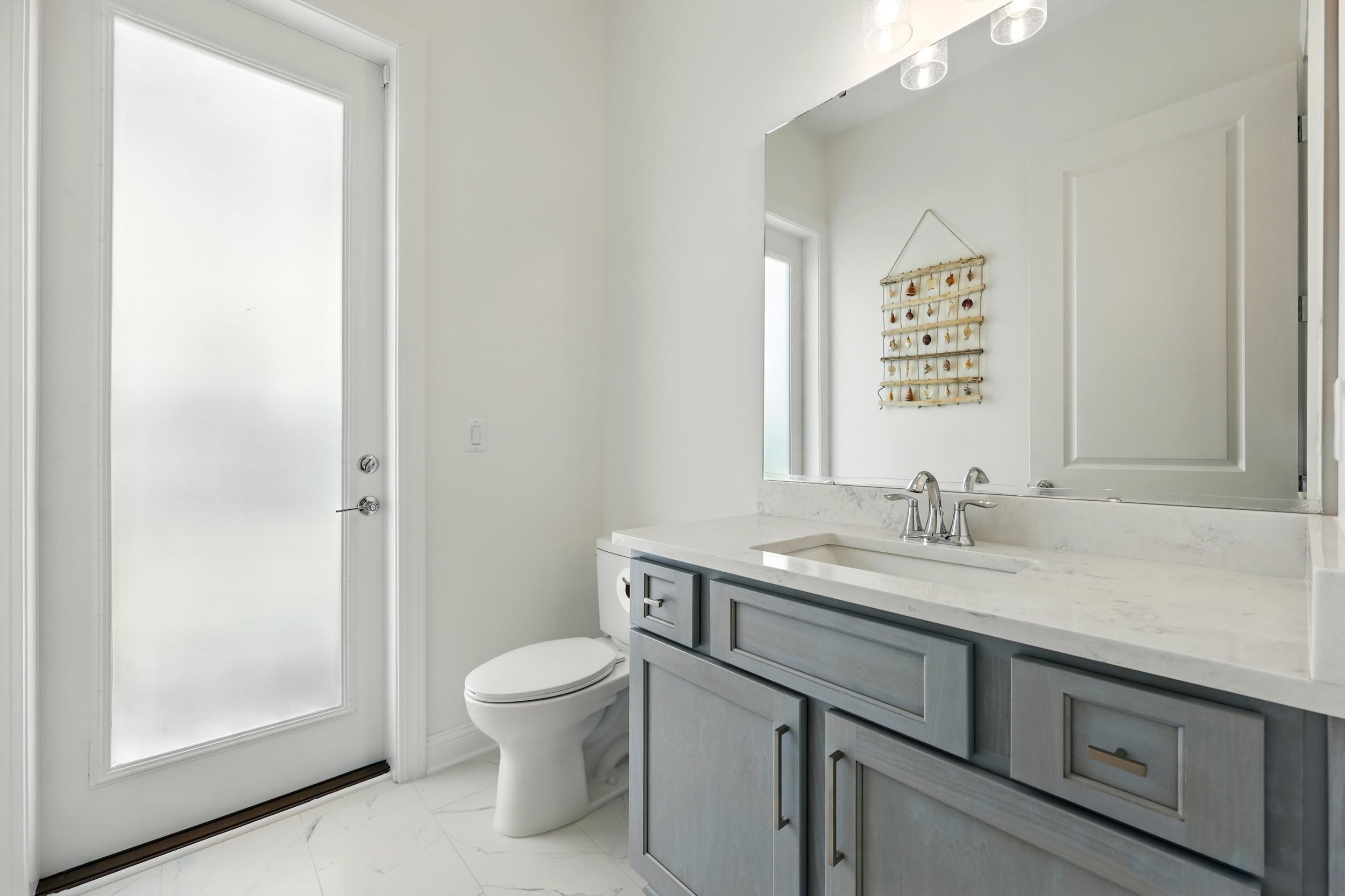 164 Tesoro Terrace St. Augustine, FL 32095 - Photo 20 of 55 a bathroom with a granite countertop sink a toilet and a mirror
