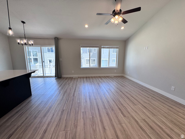 12339 Remy Road, Unit 422 Herriman, UT 84096 - Photo 13 of 36 Unfurnished living room with ceiling fan, lofted ceiling, suspended lighting, and light wood-style flooring
