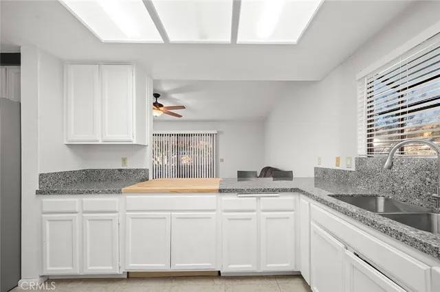 a kitchen with granite countertop white cabinets and white appliances