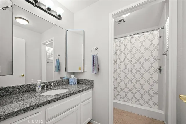 a bathroom with a granite countertop sink and a mirror