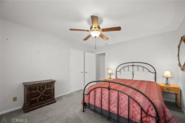 a bedroom with a bed and a ceiling fan