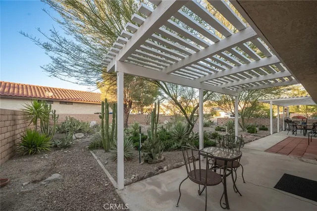 a view of a yard with table and chairs under an umbrella