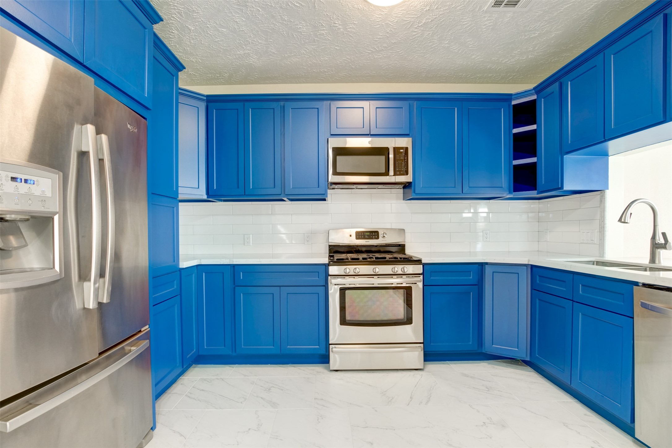 11840 Spring Grove Drive Houston, TX 77099 - Photo 8 of 27 Beautifully updated kitchen with bold blue cabinetry
