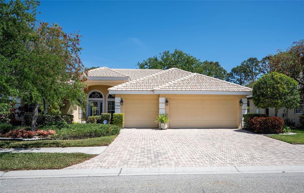956 Scherer Way Osprey, FL 34229 - Photo 2 of 38 a front view of a house with a yard and garage