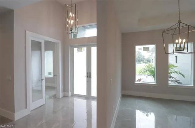 a view of hallway with windows and chandelier