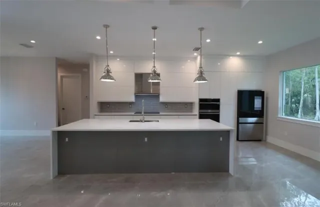 a view of kitchen with kitchen island a sink stainless steel appliances and cabinets