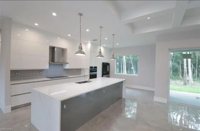 a large kitchen with kitchen island a large island in it