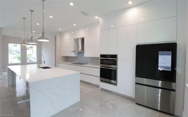 a kitchen with stainless steel appliances kitchen island granite countertop a refrigerator a sink and a stove