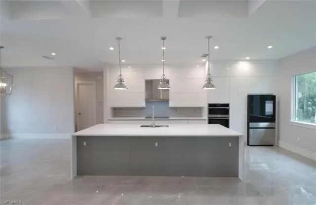 a large kitchen with stainless steel appliances a large counter top