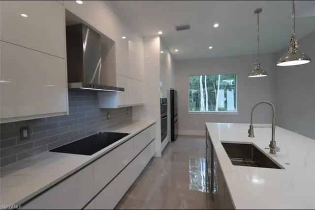 a kitchen with stainless steel appliances a sink a stove a microwave a sink a refrigerator and cabinets