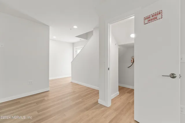a view of a hallway with wooden floor
