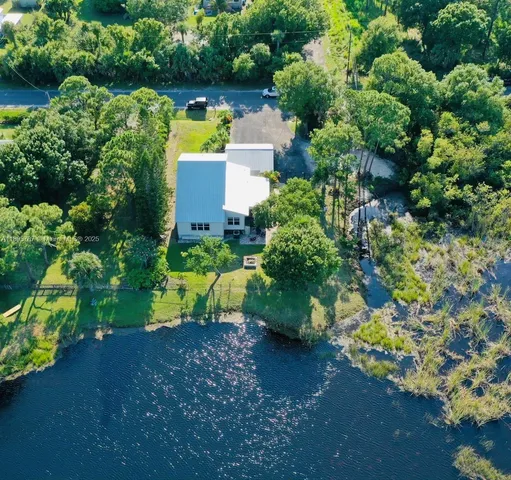 an aerial view of a house with a yard swimming pool and outdoor seating