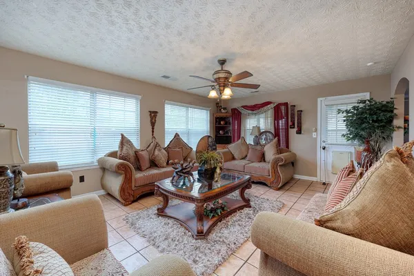 a living room with furniture a chandelier and a window