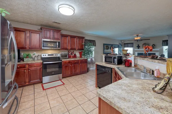a kitchen with stainless steel appliances granite countertop a sink dishwasher stove top oven and cabinets