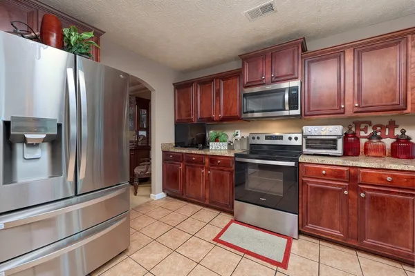 a kitchen with stainless steel appliances granite countertop a refrigerator stove and sink
