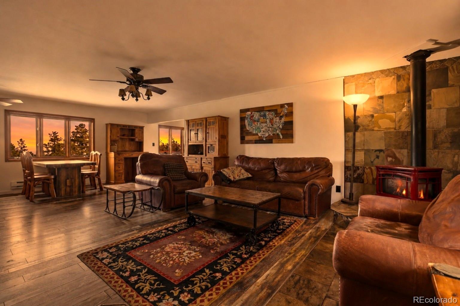 9225 Sandy Lane Conifer, CO 80433 - Photo 4 of 45 a living room with furniture ceiling fan and a rug