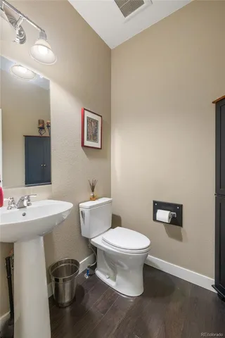 a bathroom with a toilet a sink and mirror