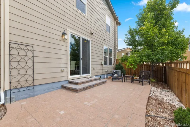 a view of backyard with a table and chairs and wooden fence