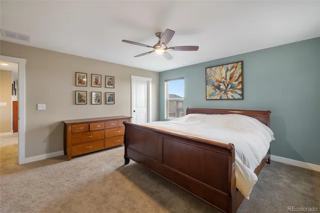 a spacious bedroom with a bed and a dresser