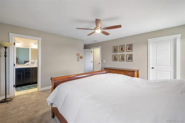 a bedroom with a large bed and a chandelier