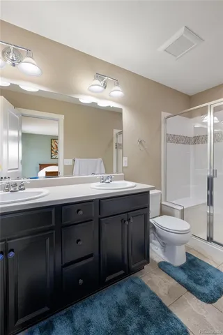 a bathroom with a double vanity sink toilet and a mirror