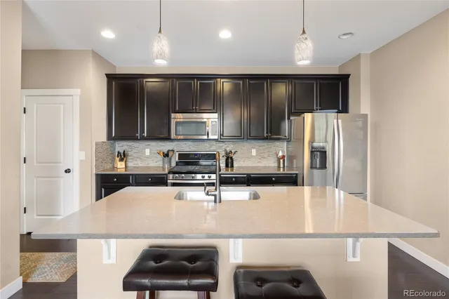 a kitchen with kitchen island a counter space stainless steel appliances and cabinets