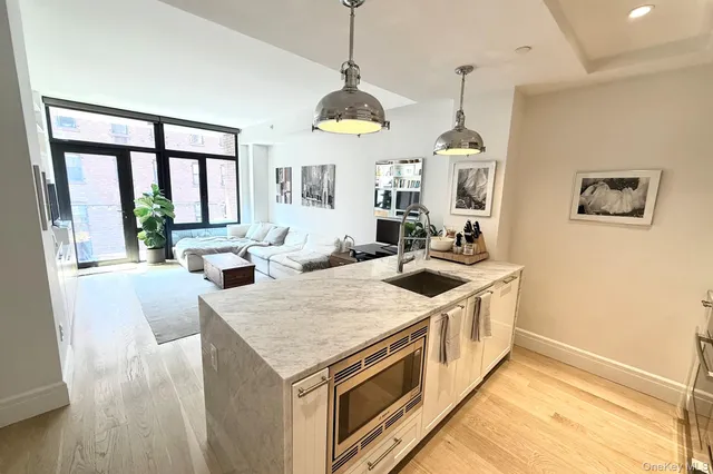 a kitchen that has a lot of white cabinets and a wooden floor