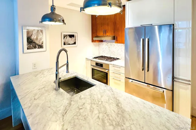 a kitchen with granite countertop a refrigerator and a stove