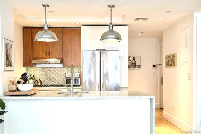 a bathroom with a granite countertop sink a mirror and shower