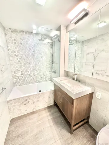 a spacious bathroom with a tub sink and mirror