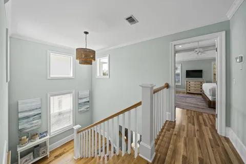 a view of a hallway with wooden floor and staircase