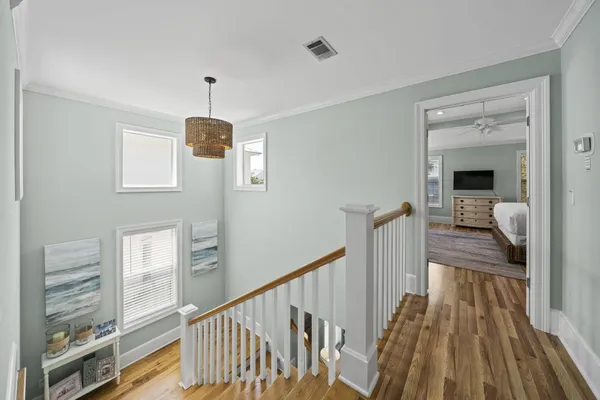 a view of a hallway with wooden floor and staircase