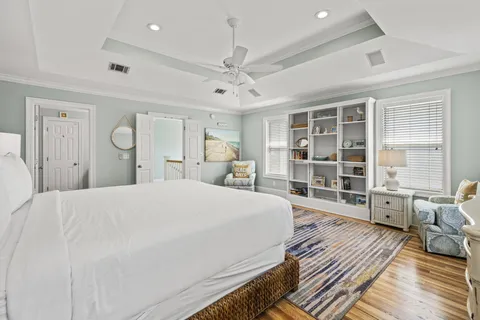 a spacious bedroom with a bed a table and large window
