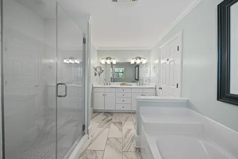a bathroom with a tub sink shower and mirror