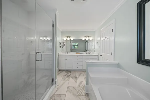 a bathroom with a tub sink shower and mirror