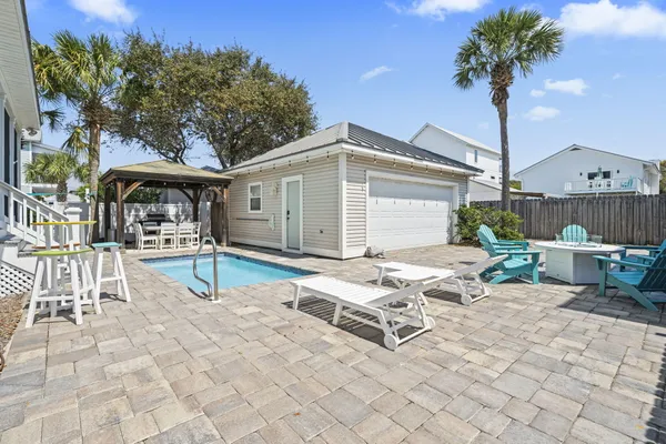 a white building with outdoor seating and a potted plant