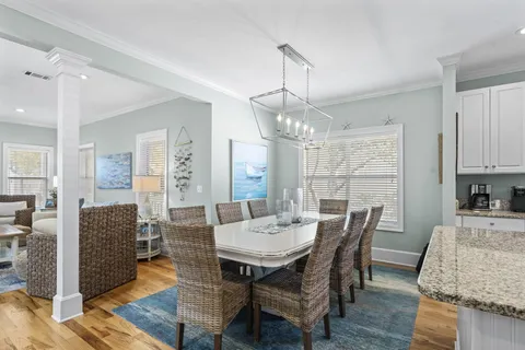 a view of a dining room with furniture a chandelier and wooden floor