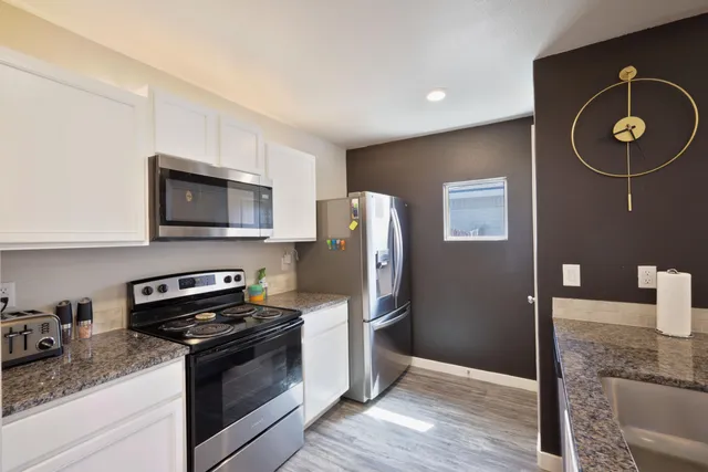 a kitchen with granite countertop stainless steel appliances and wooden cabinets
