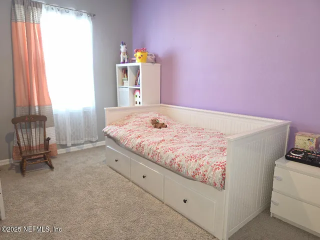 a bed room with a bed and a chair