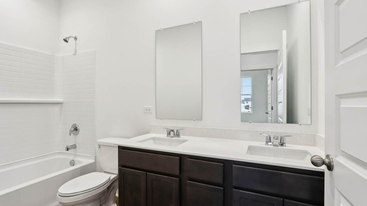 7641 West 106th Place Crown Point, IN 46307 - Photo 11 of 31 a bathroom with a granite countertop sink toilet a large mirror a bathtub and shower