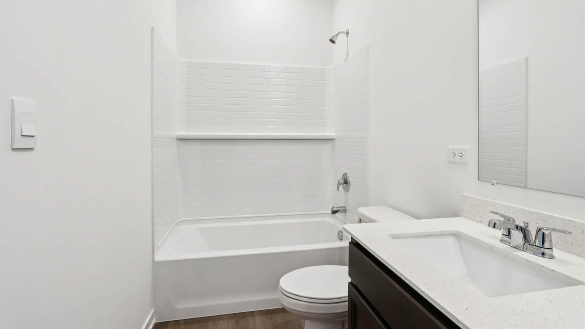 7641 West 106th Place Crown Point, IN 46307 - Photo 12 of 31 a bathroom with a bathtub shower sink vanity mirror and toilet