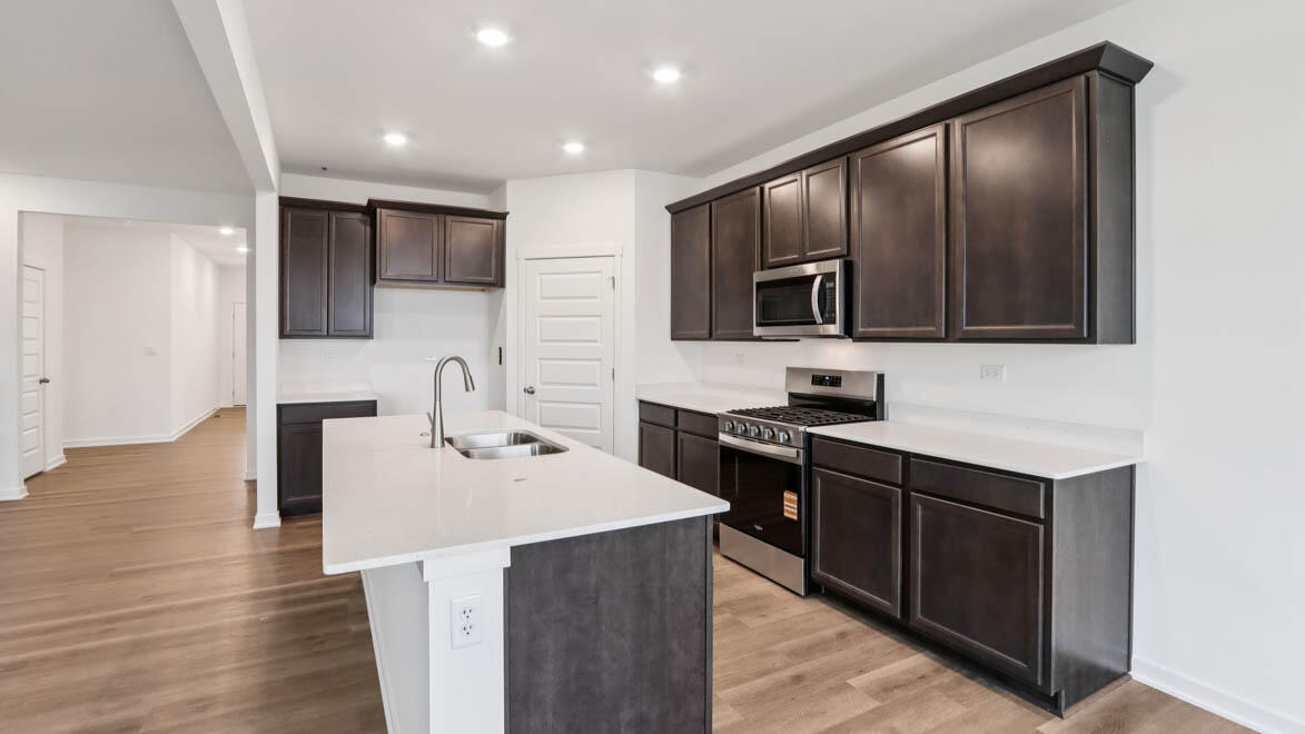 7641 West 106th Place Crown Point, IN 46307 - Photo 6 of 31 a kitchen with stainless steel appliances granite countertop a sink stove and microwave