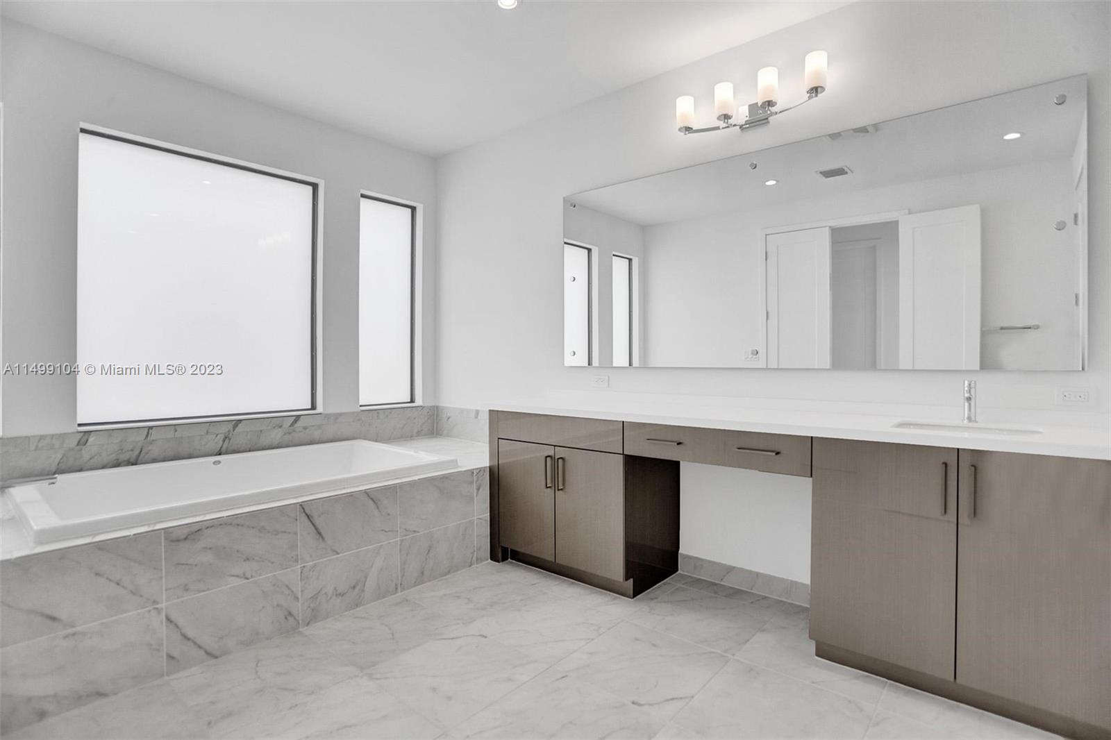 17185 Teton River Road Boca Raton, FL 33496 - Photo 62 of 89 a spacious en suite bathroom with a large tub double vanity sink and a large mirror